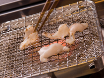 Akashi_Grilled puffer fish. A deboned puffer fish is grilled over a charcoal fire.