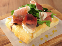 ROSEMARY'S TOKYO_[Focaccia with Cured Ham, Argula, and Seasonal Fruits] Like a salad, enjoy this dish topped with various ingredients.